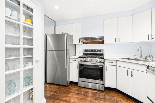 1 W 67th St Unit 2E, New York City, NY 10023 - kitchen featuring stainless steel appliances, range hood, a sink, light countertops, and white cabinetry