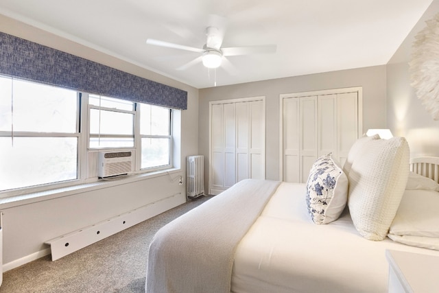 carpeted bedroom featuring cooling unit, multiple closets, radiator heating unit, and ceiling fan