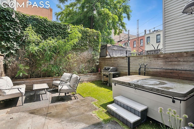 view of patio / terrace with a hot tub and a grill