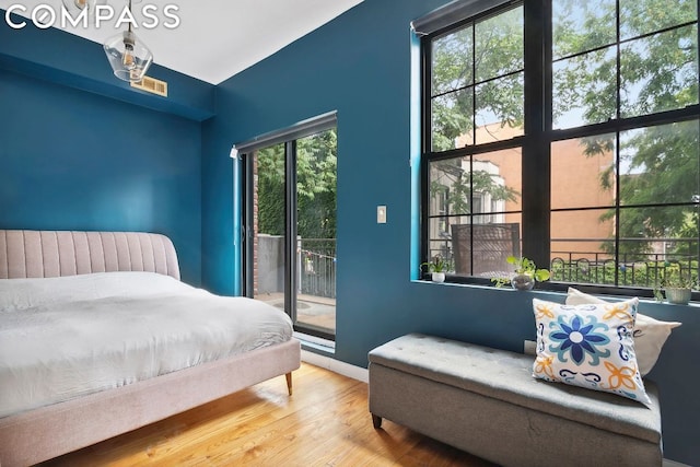 bedroom featuring access to exterior and wood-type flooring