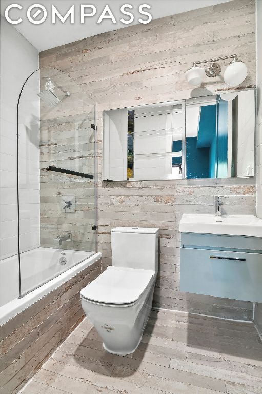 full bathroom with toilet, vanity, and tiled shower / bath combo