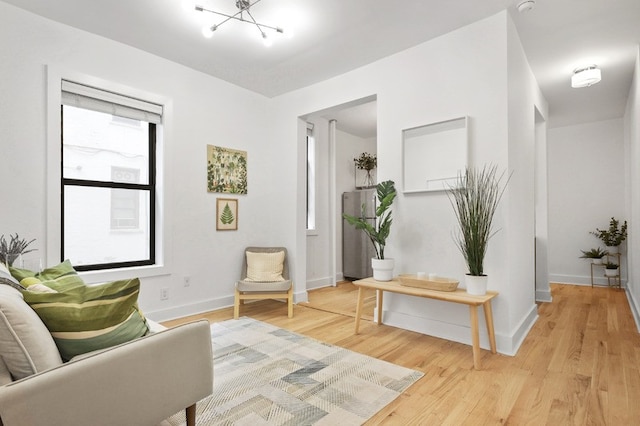 sitting room with an inviting chandelier and light wood-type flooring