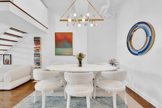 dining room with a notable chandelier, baseboards, and wood finished floors