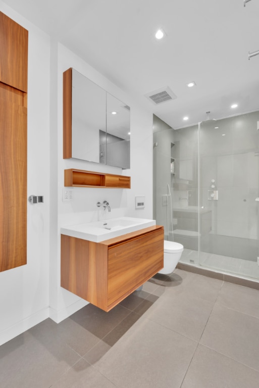 full bath featuring visible vents, toilet, tile patterned floors, vanity, and a shower stall