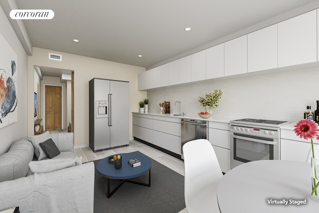 kitchen featuring appliances with stainless steel finishes, light countertops, a sink, and visible vents