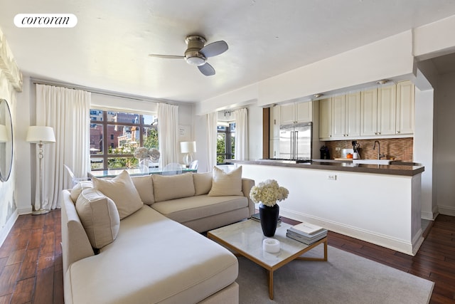 living room featuring dark wood-type flooring, ceiling fan, and sink