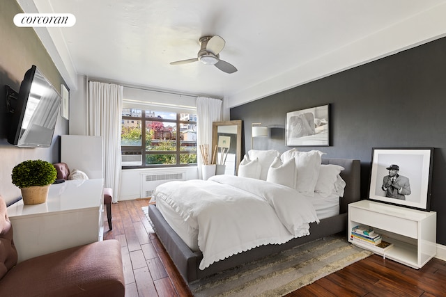 bedroom with radiator heating unit, wood-type flooring, visible vents, and a ceiling fan