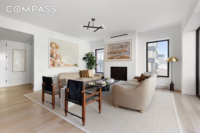 living area with a fireplace, wood finished floors, and baseboards