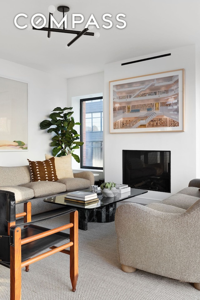 carpeted living room featuring a glass covered fireplace