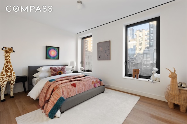 bedroom with baseboards and wood finished floors