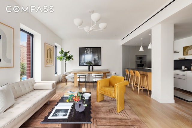 living area with light wood-style floors and a chandelier