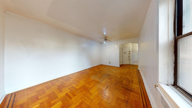 empty room with ceiling fan and light parquet flooring