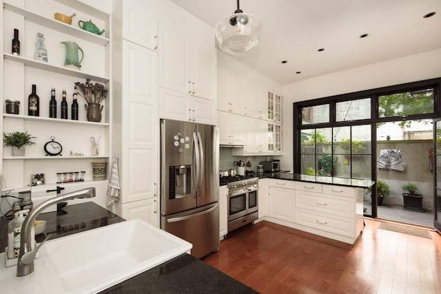 kitchen with a sink, stainless steel appliances, open shelves, and dark wood-style floors