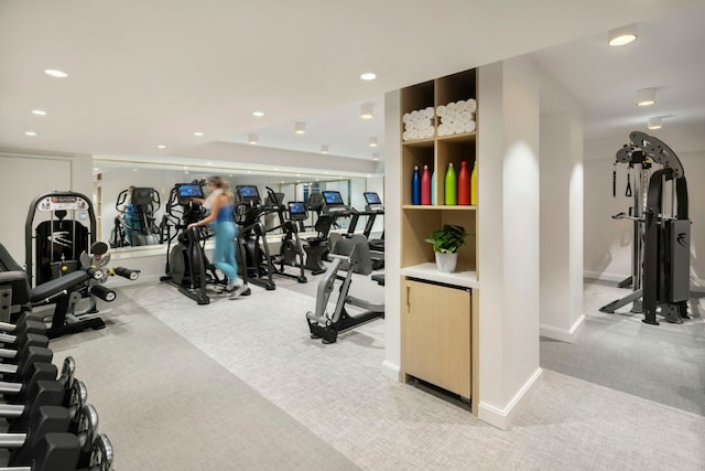 exercise room featuring light carpet