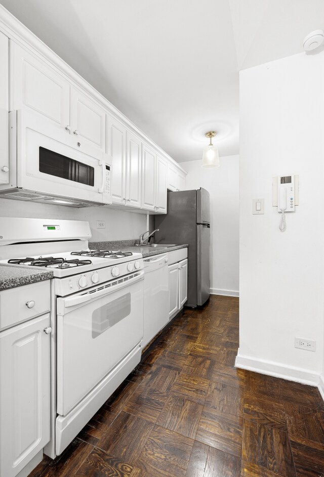 305 W 18th St Unit 1K, New York City, NY 10011 - kitchen with white appliances, white cabinets, baseboards, and a sink
