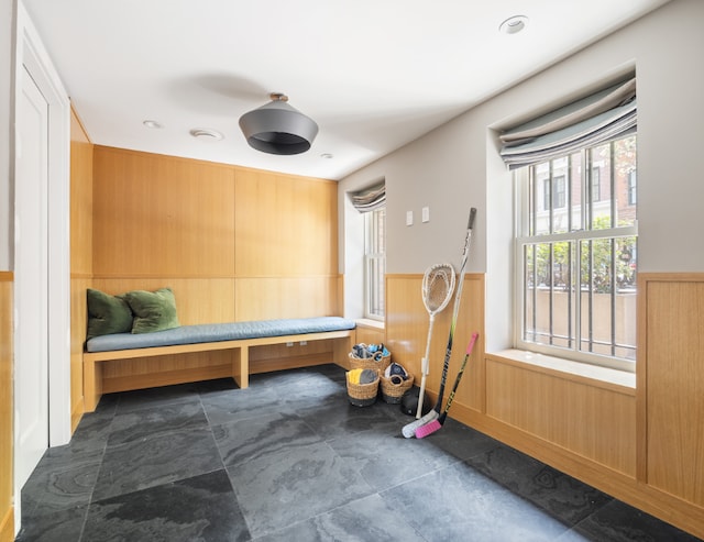 mudroom featuring wooden walls