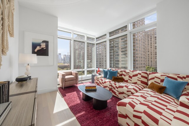 living room with a wall of windows, plenty of natural light, and hardwood / wood-style floors