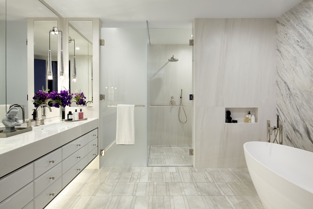 bathroom featuring vanity, independent shower and bath, and tile walls