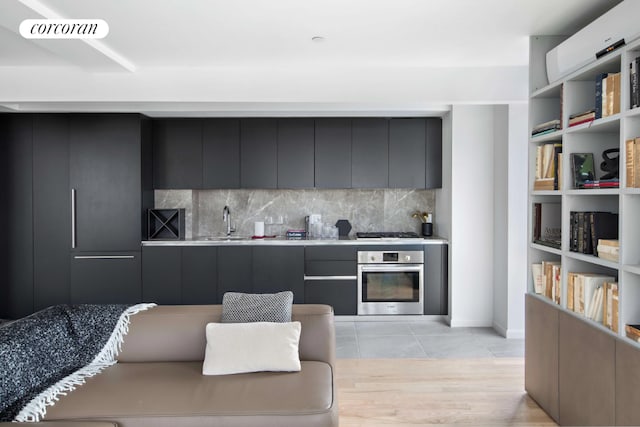 kitchen featuring tasteful backsplash, appliances with stainless steel finishes, light tile patterned flooring, and sink