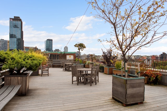 wooden deck with outdoor dining space and a city view