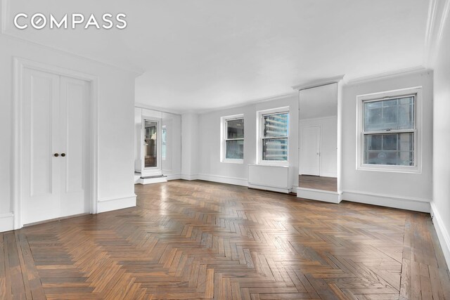 unfurnished living room with dark parquet flooring