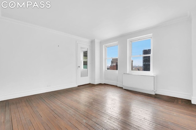 empty room with dark hardwood / wood-style floors and ornamental molding