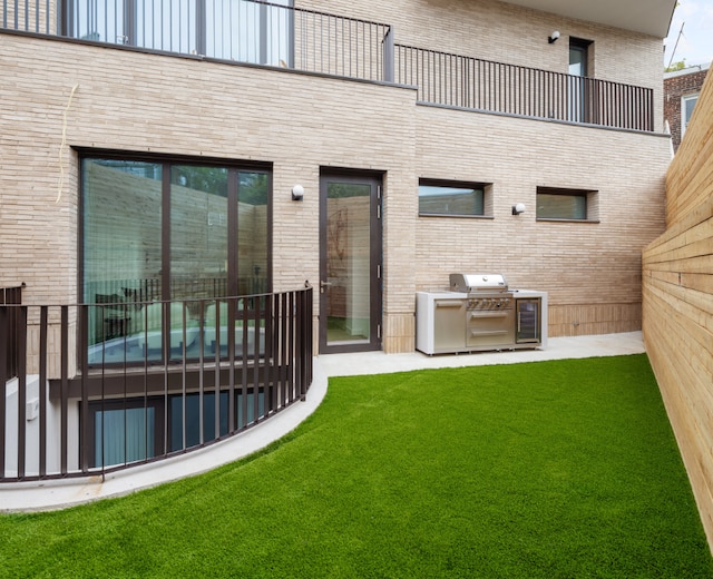 rear view of property featuring a yard and area for grilling