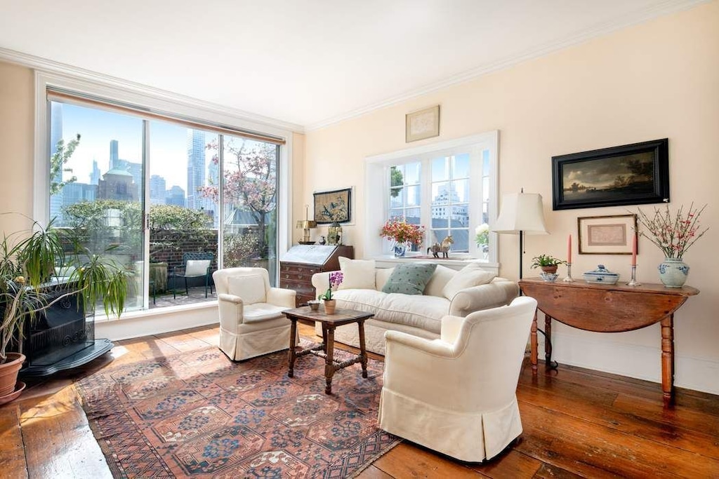 living room with a city view, crown molding, and wood-type flooring