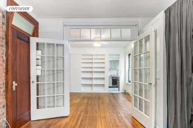 interior space with a ceiling fan, french doors, and wood-type flooring