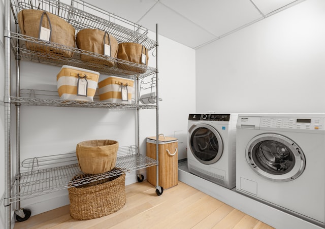 laundry area with hardwood / wood-style flooring and washing machine and clothes dryer