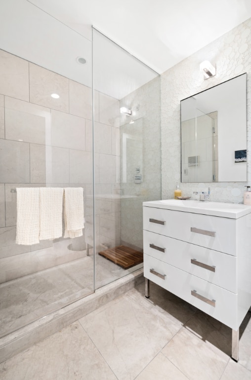 bathroom with vanity and tiled shower