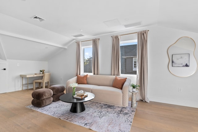 living room featuring visible vents, wood finished floors, baseboards, attic access, and vaulted ceiling