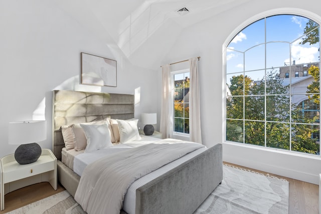 bedroom featuring visible vents, multiple windows, and wood finished floors