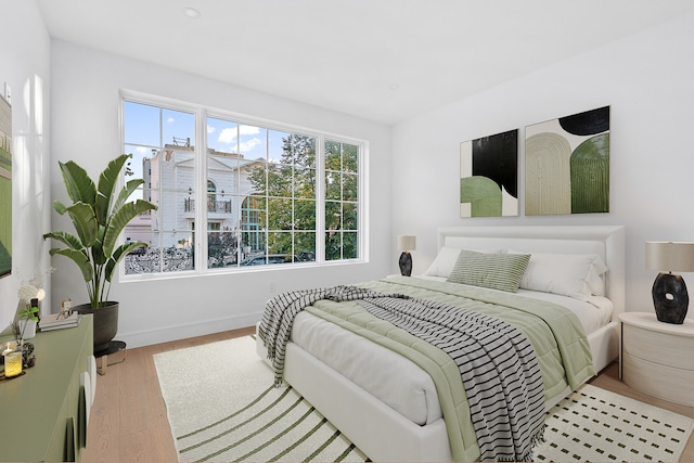 bedroom with baseboards and wood finished floors