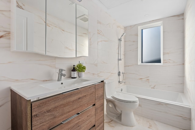 bathroom with toilet, tile walls, vanity, and washtub / shower combination