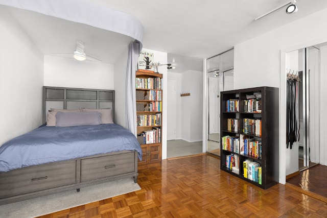 bedroom with ceiling fan and dark parquet floors