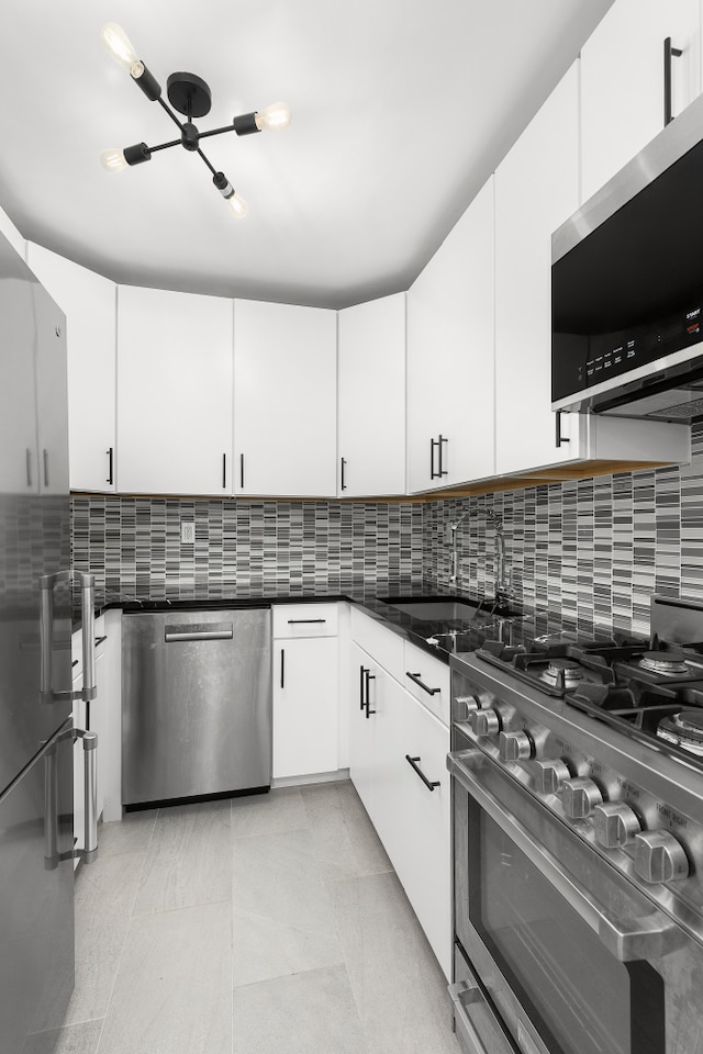 kitchen featuring a sink, tasteful backsplash, appliances with stainless steel finishes, and white cabinets