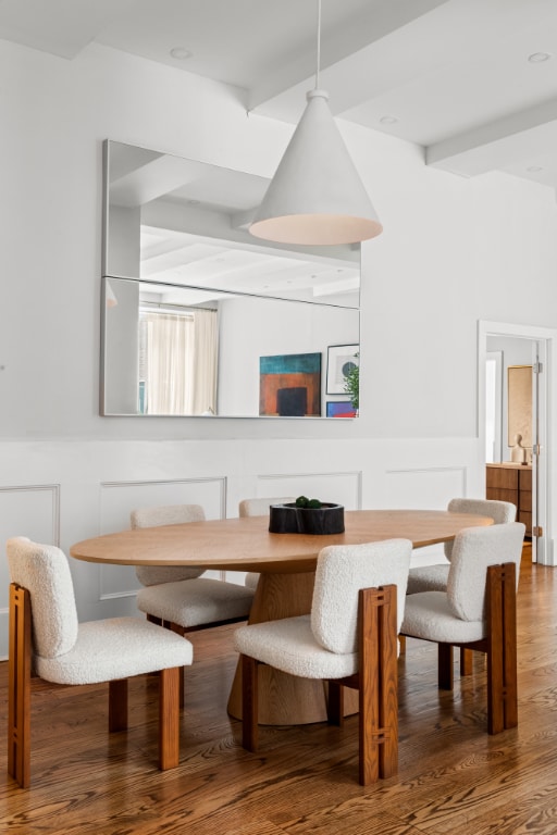 dining room with beamed ceiling and hardwood / wood-style floors