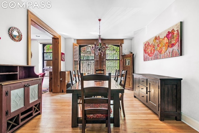 dining area featuring light hardwood / wood-style floors and a notable chandelier