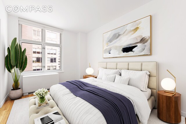 bedroom featuring hardwood / wood-style flooring and radiator heating unit