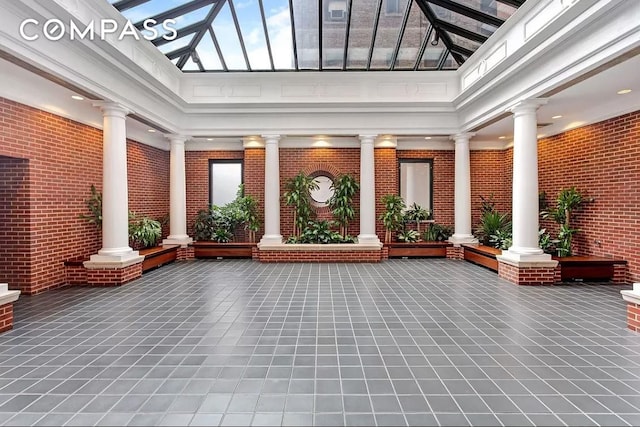 lobby featuring brick wall and a high ceiling