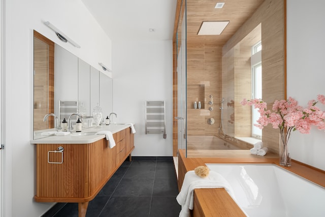 full bathroom with double vanity, a shower, radiator heating unit, tile patterned floors, and a sink