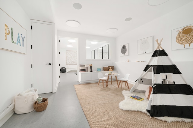 bedroom with finished concrete flooring and baseboards