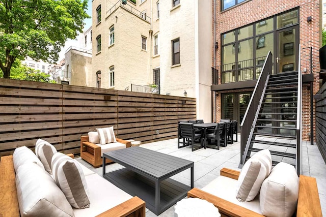 view of patio featuring outdoor dining area, outdoor lounge area, and stairs