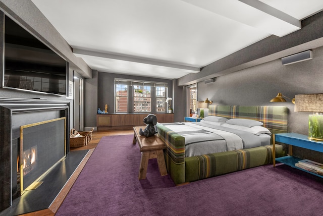 bedroom with a warm lit fireplace and beam ceiling