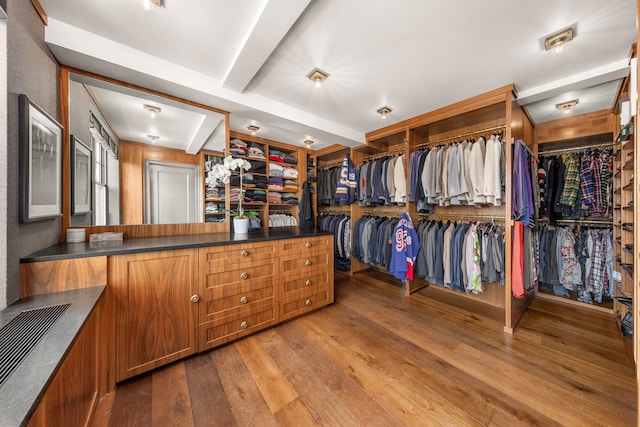 spacious closet featuring visible vents, hardwood / wood-style floors, and beamed ceiling