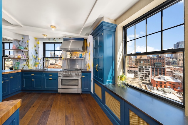 kitchen with high end stove, blue cabinetry, range hood, and open shelves