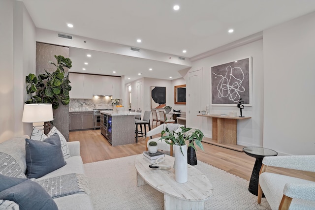 living room featuring recessed lighting, light wood finished floors, and visible vents