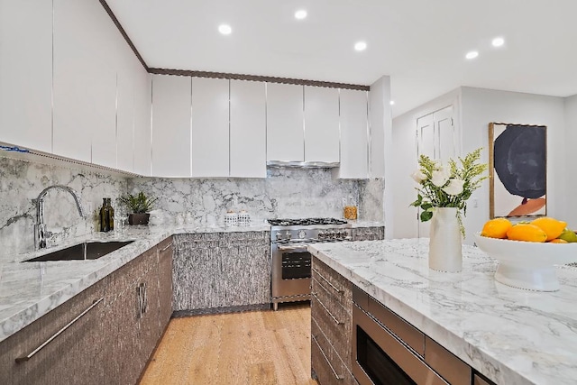 kitchen with light stone counters, sink, appliances with stainless steel finishes, and tasteful backsplash