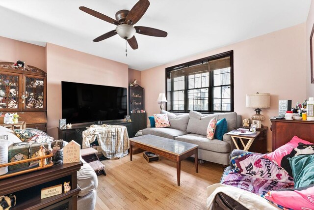 living room featuring ceiling fan and dark hardwood / wood-style flooring